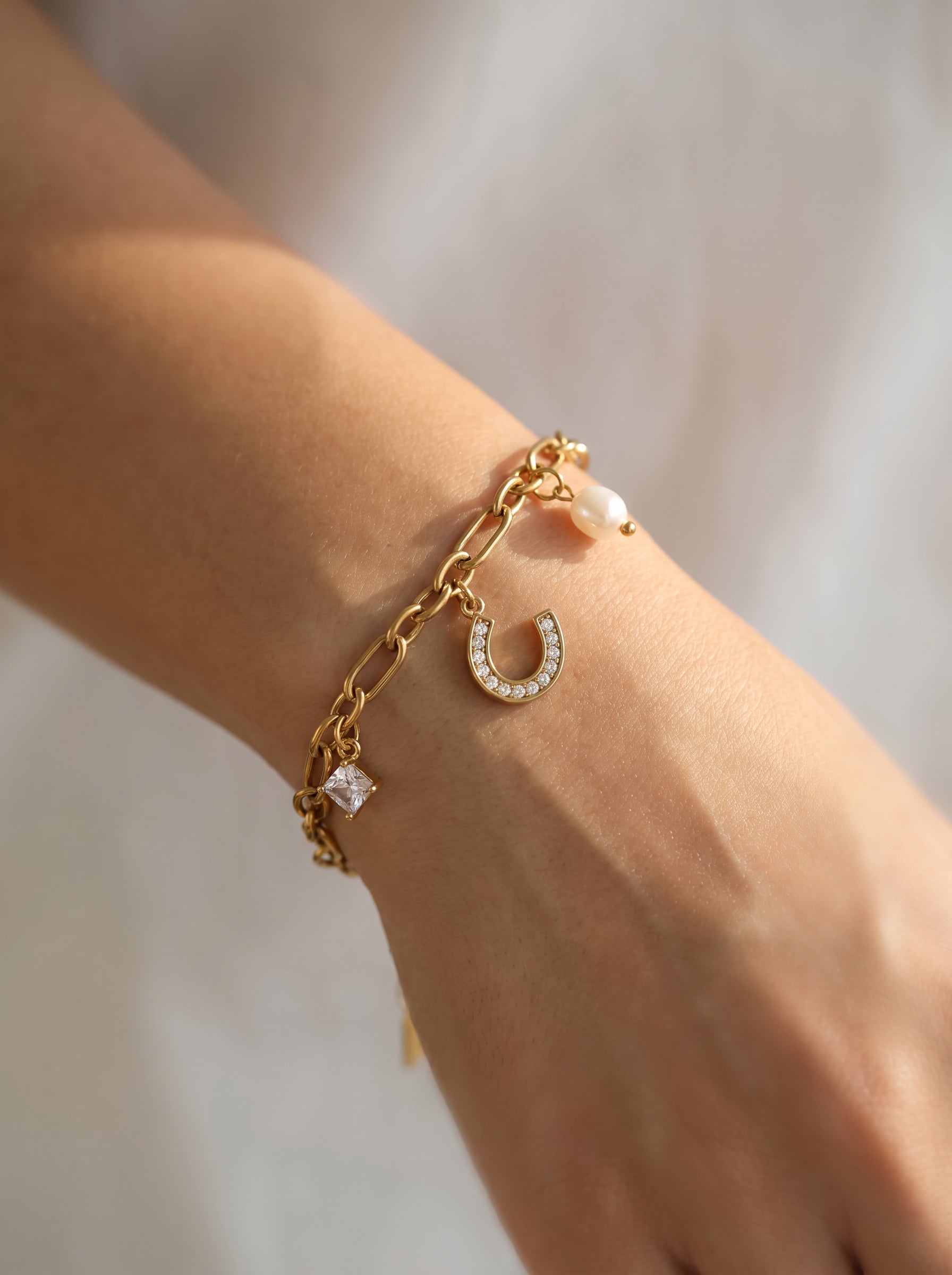 Aura Horseshoe & Pearl Charm Bracelet on white background